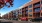 a street with cars parked in front of a long building