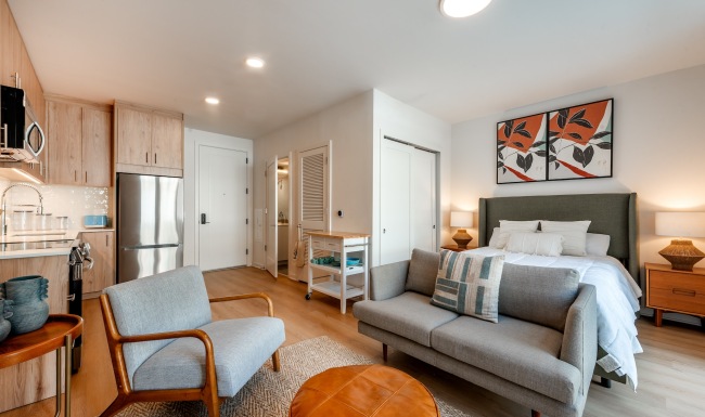 Spacious Studio Model studio apartment at The Glade on Laurel Apartments in Washington DC, featuring wood grain floor paneling.